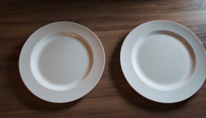  a couple of white plates sitting on top of a wooden table next to each other on top of a wooden table next to a bottle of some sort of wine.