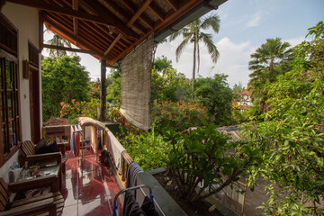 A serene balcony view overlooking a lush tropical garden.