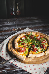 Appetizing lush pizza on a dark wooden background.