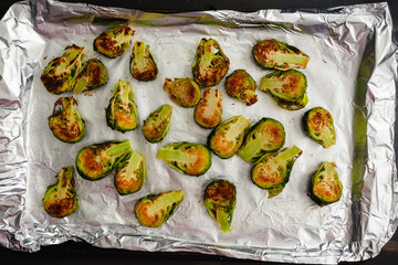 Roasted Brussels Sprout Haves on a Foil-Lined Sheet Pan: Browned baby cabbages on a cookie sheet...