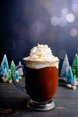 Spiced Christmas Coffee Topped with Whipped Cream and Cinnamon Sugar: Large glass mug of freshly brewed spiced coffee with miniature Christmas trees