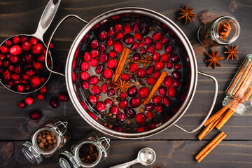 Making Spiced Cranberry Simple Syrup in a Small Pan: Simmering sugar, cranberries, cinnamon sticks,...