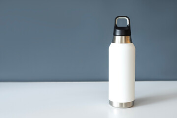 Reusable eco steel thermo water bottle on table. 