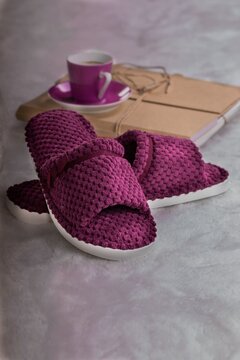 Soft burgundy slippers on the background of a coffee cup