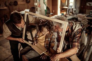 Three generations of men in a woodworking workshop