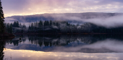 Fototapeta na wymiar Fog Covered Fairy Lake in Canadian Nature Landscape Background.