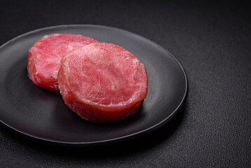 Round shape steaks of raw juicy tuna with salt and spices