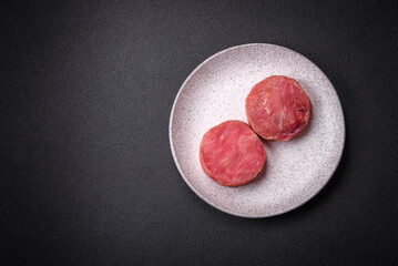 Round shape steaks of raw juicy tuna with salt and spices