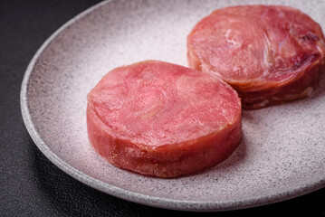 Round shape steaks of raw juicy tuna with salt and spices