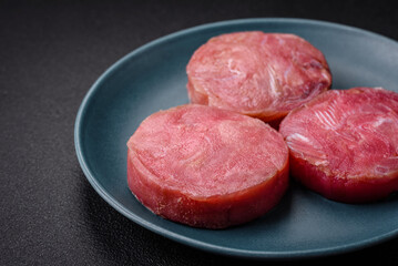 Round shape steaks of raw juicy tuna with salt and spices
