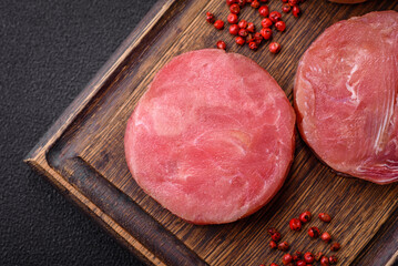 Round shape steaks of raw juicy tuna with salt and spices