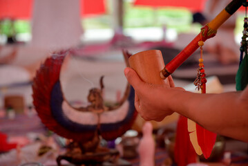 hands of a person, hands of a person in a temple, shaman, holding pipe, shamanic pipe, religious ritual, shamanic ritual, spiritual ceremony setup, hand holding ceremonial cup and pipe