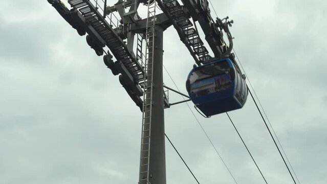 Blue funicular cable car offers a scenic touristic ride to reach destination, against sky background. Public transportation and recreational experience, perfect vacation