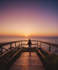 Woman standing on a pier in the evening