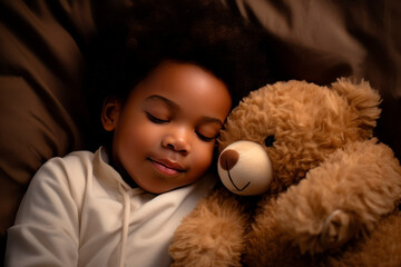 a darkskinned boy sleeps sweetly in bed with a toy bear in his arms under the blanket