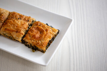 borek with spinach on white wooden table