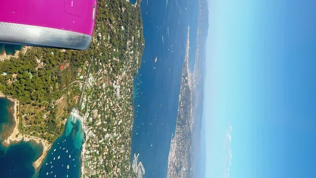 Stunning aerial vertical view of the island from the airplane window. Slow motion. Coastlines of Cannes, France