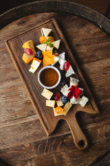 Mix of cheeses with honey, berries and a glass of white wine.