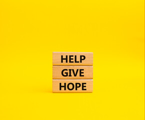 Help Give Hope symbol. Concept words Help Give Hope on wooden blocks. Beautiful yellow background. Business and Help Give Hope concept. Copy space.