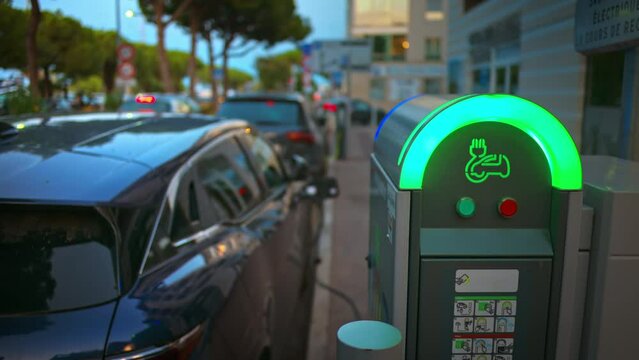 Electric car charging at a public charging station in the evening