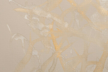 Gold glitter Ink watercolor drop blot on beige paper texture background.