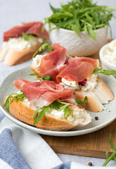 Sandwiches with jamon, cream cheese and arugula. Traditional European breakfast.