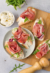 Sandwiches with jamon, cream cheese and arugula. Traditional European breakfast.