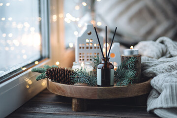 Natural Christmas essential oil, home aroma diffuser. Burning candles, branches of fir tree....