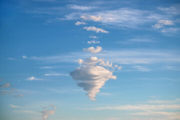 Strange cloud shaped like a cone. Blue sky with fluffy cloud as a natural background