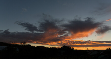 Landscape at sunset. Tragic gloomy sky. The village in the Budjak steppe. The terrain in southern Europe. Panorama. Crimson twilight.