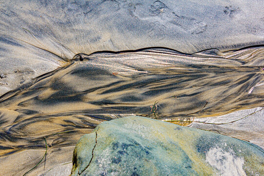 rivulet flowing over the sand on the beach