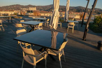 tables of an open-air restaurant on the terrace of a tourist resort, a table set with modern tables...