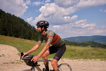 Cyclist practicing on gravel road.Male cyclist riding a gravel bike on a gravel road with a view of...