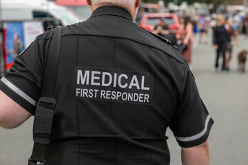 A close-up of a Caucasian male emergency health medical first responder or paramedic wearing a...