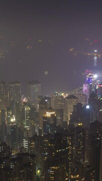 Illuminated Hong Kong Skyline at Night. Vertical Panoramic Time Lapse. View From Victoria Peak. Vertical Video