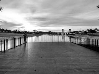 Obraz premium Puncak Alam, Selangor, Malaysia, November 10, 2022: Embracing Eco Grandeur: A Magnificent View of the Bridge, a Harmony of Nature, lake, Architecture and a one man on the frame in black and white.