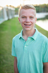 Portrait of smiling blonde teenage boy wearing a collared shirt with braces on his face. Authentic Real people concept photo