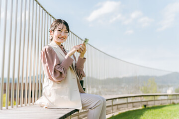 スマホで・スマートフォンを使って電話する女性・ビジネスウーマン
