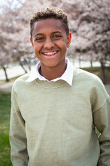 Portrait of smiling African American teenage boy with braces wearing a hoodie sweatshirt. Authentic...