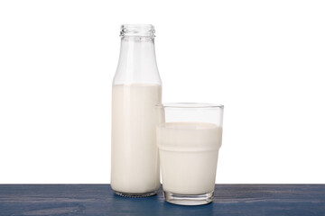 Glassware with tasty milk on blue wooden table against white background