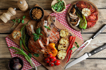 Delicious grilled meat and vegetables served on wooden table, flat lay