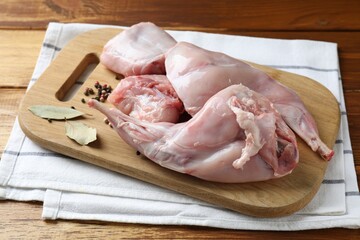 Fresh raw rabbit meat and spices on wooden table
