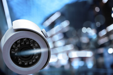Modern security CCTV camera against blurred background, space for text