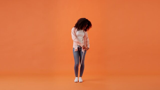 African American woman measures hip girth rejoicing in room