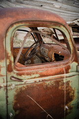 old rusty truck in field in nebraska with broken glass