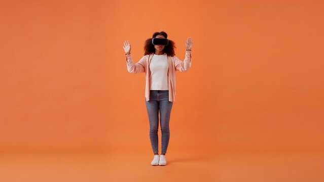 African American lady plays game in virtual reality glasses
