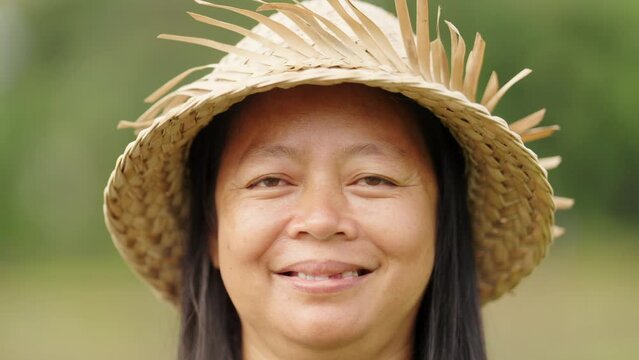 Smiling asian woman in straw hat with missing teeth, dental health