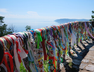 Buddhist ritual place with colored ribbons  at the holy site of Lake Baikal. Sacred place, pillar ...