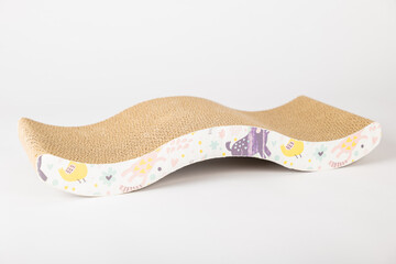 On a white backdrop a cat's playful paw meets a modern corrugated cardboard scratching post also a comfy lounge bed. textured design sparks the cat's curiosity and makes it a staple for feline care.