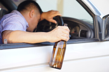 Drunk man holds beer bottle in car. Concept , Campaign for don't drive, don't drink alcohol that...